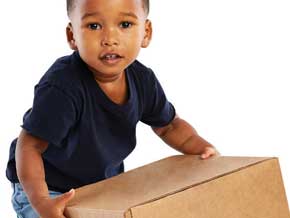 Toddler boy lifting a brown box