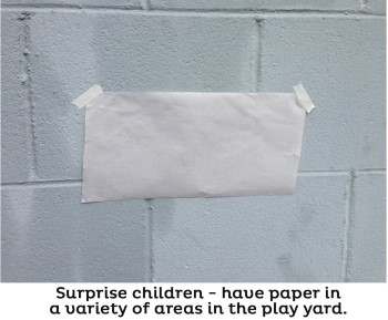 large white paper taped to outdoor wall for outdoor art activity