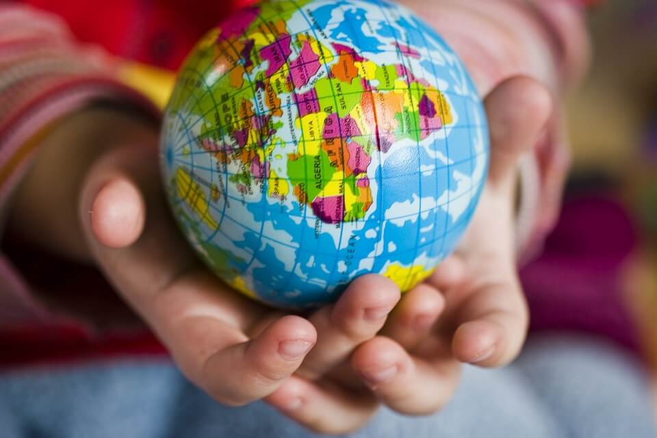 a young child holding a classroom globe