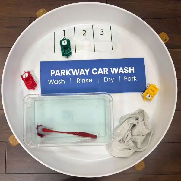 Vehicle-themed tuff tray activity supporting counting and fine motor development.