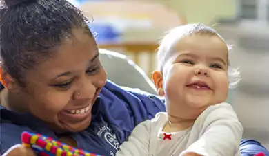 early childhood caregiver and infant reading a book