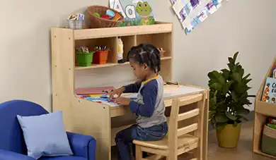 Preschool child sitting at Beckers writing table