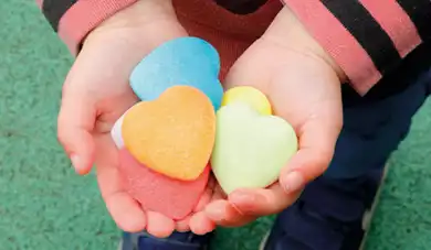 child holding colorful kindness hearts