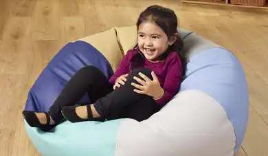 Preschool child sitting on a bean bag chair