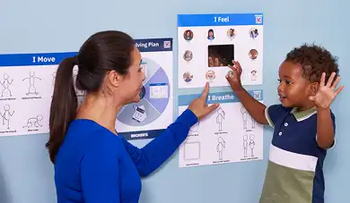Teacher and toddler pointing at posters in a Cozy Corner