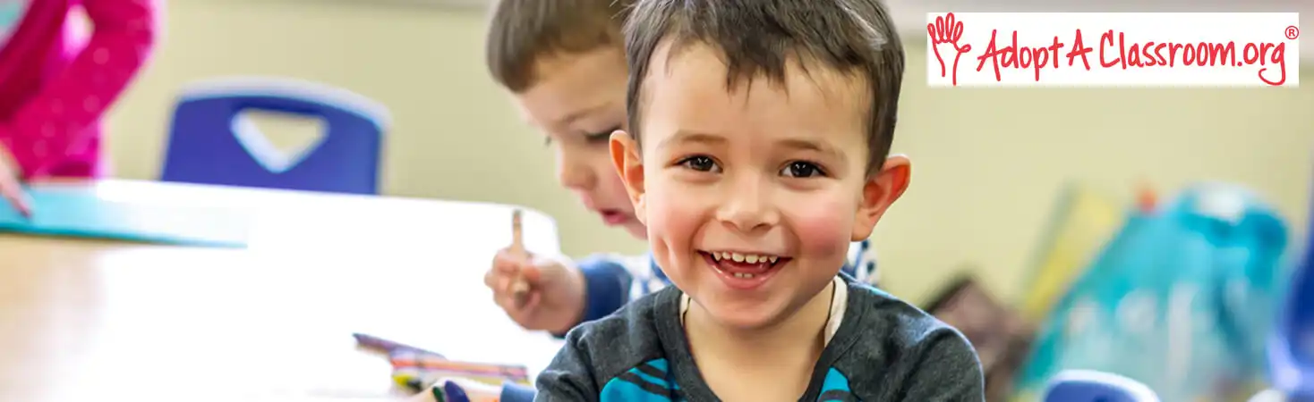 Preschool child sitting at table in classroom