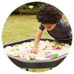 ​​Preschool boy exploring sand in a Tuff Tray