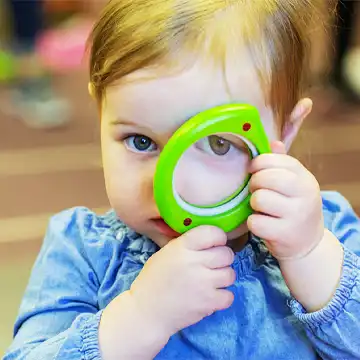 Toddler looking through magnifying glass 