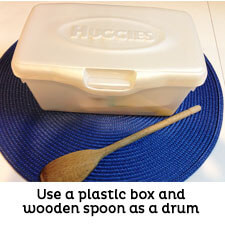 White box with lid and wooden spoon to use as drum