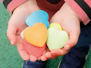 Child holding Yellow Door Kindness Hearts