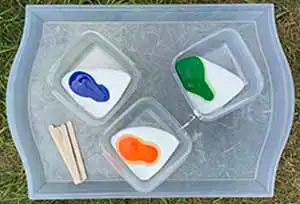 Pouring tempera paint into bowls with white glue