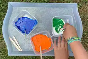 Stirring tempera paint into bowls with white glue