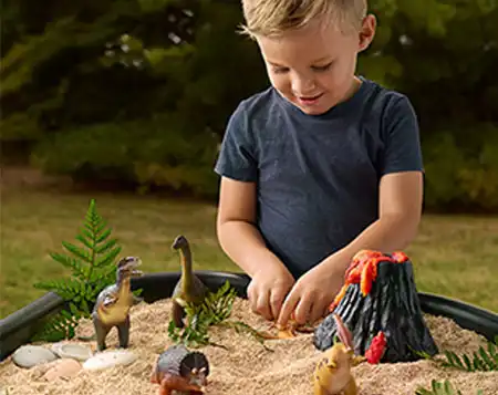 A child enjoying sensory play outside with in a Tuff Tray from Becker’s School Supplies