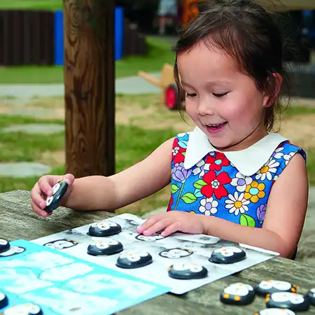 Girl playing with coding penguins