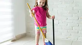 young child sweeping