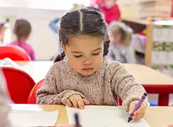 Preschool child drawing with a crayon