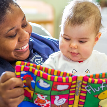 Early Head Start caregiver reading to baby