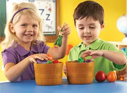 Preschool children in classroom playing with Sprouts Bushel of Fruit