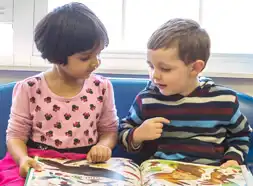 Preschool children reading a book