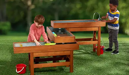 ​​Children playing outside in sensory water table​ 