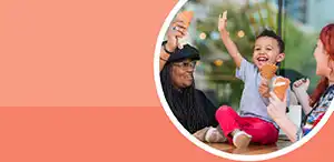 Preschool child eating ice cream with two women