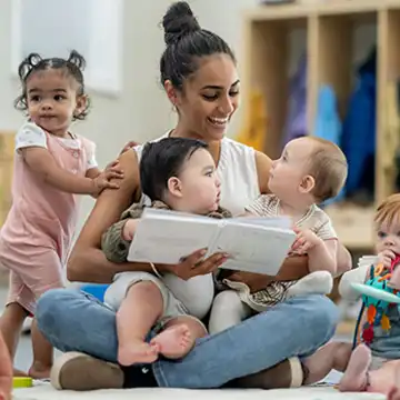 Teacher reading to infants in classroom